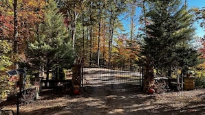 A forested area with a gated entrance, solar-powered lights, and a clear sky. - Lakefront 3-bedroom cabin on Fontana Lake with stunning views and a private dock (Robbinsville)