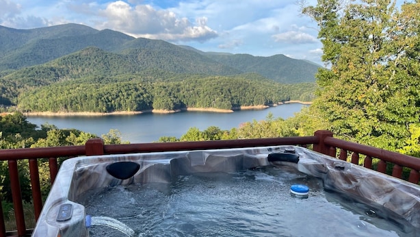 A hot tub with a view of a lake and mountains. - Lakefront 3-bedroom cabin on Fontana Lake with stunning views and a private dock (Robbinsville)