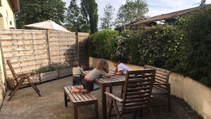 An outdoor patio with wooden furniture and a brick floor. - Le Duplex - Pontaly Farm (BAILLY)