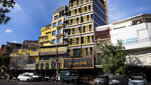 Un edificio de varios pisos con fachada amarilla y varias balcones.