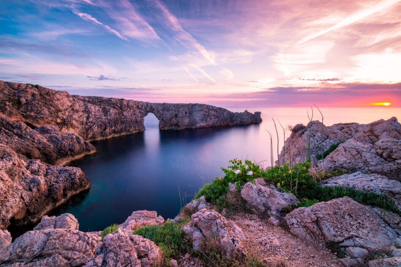 Un paysage côtier caractérisé par une formation rocheuse naturelle et un étroit passage.
