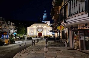 Une église dotée d’un clocher, d’un chemin piétonnier pavé et d’une boutique dont l’enseigne indique « Papeterie ».
