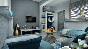 A modern living room with a sofa, a coffee table, and a TV mounted on the wall. - Kellys Plus (Rhodes)
