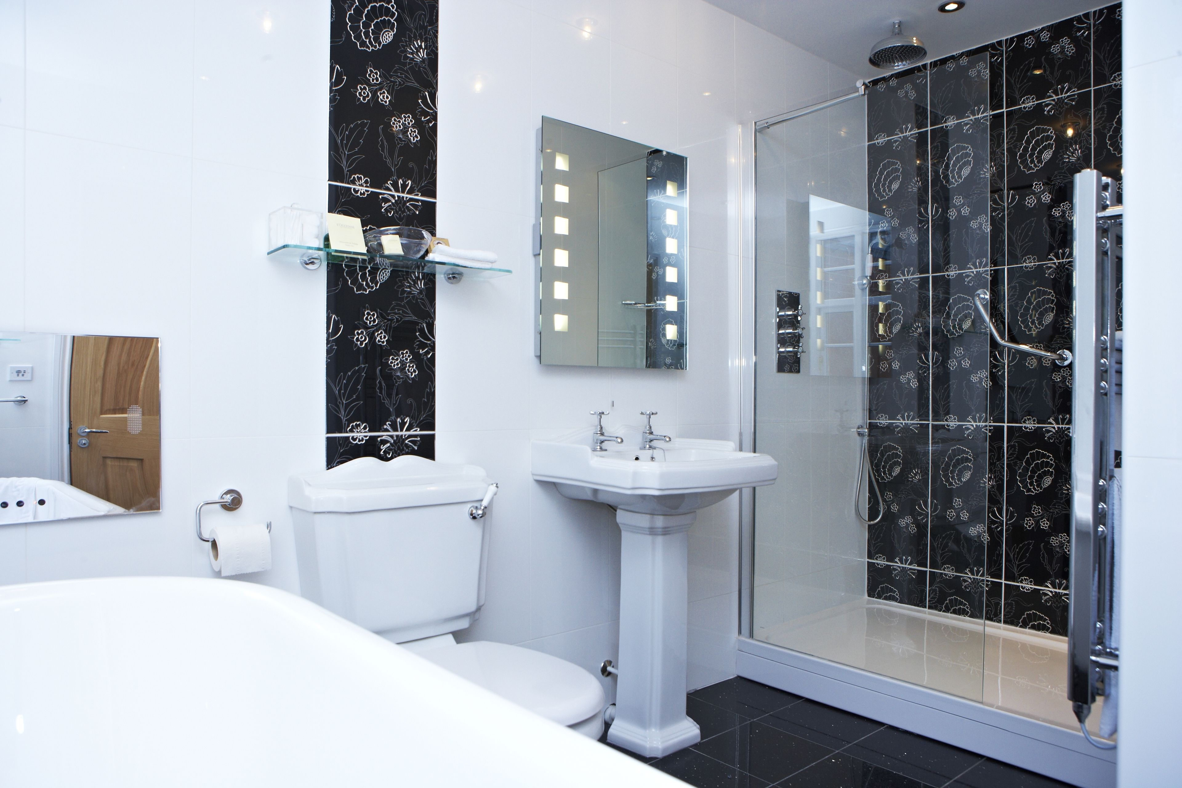 Un baño moderno con inodoro, lavabo y cabina de ducha de cristal.