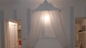 Ein Schlafzimmer mit Baldachinbett, Nachttisch und Beistelltisch.