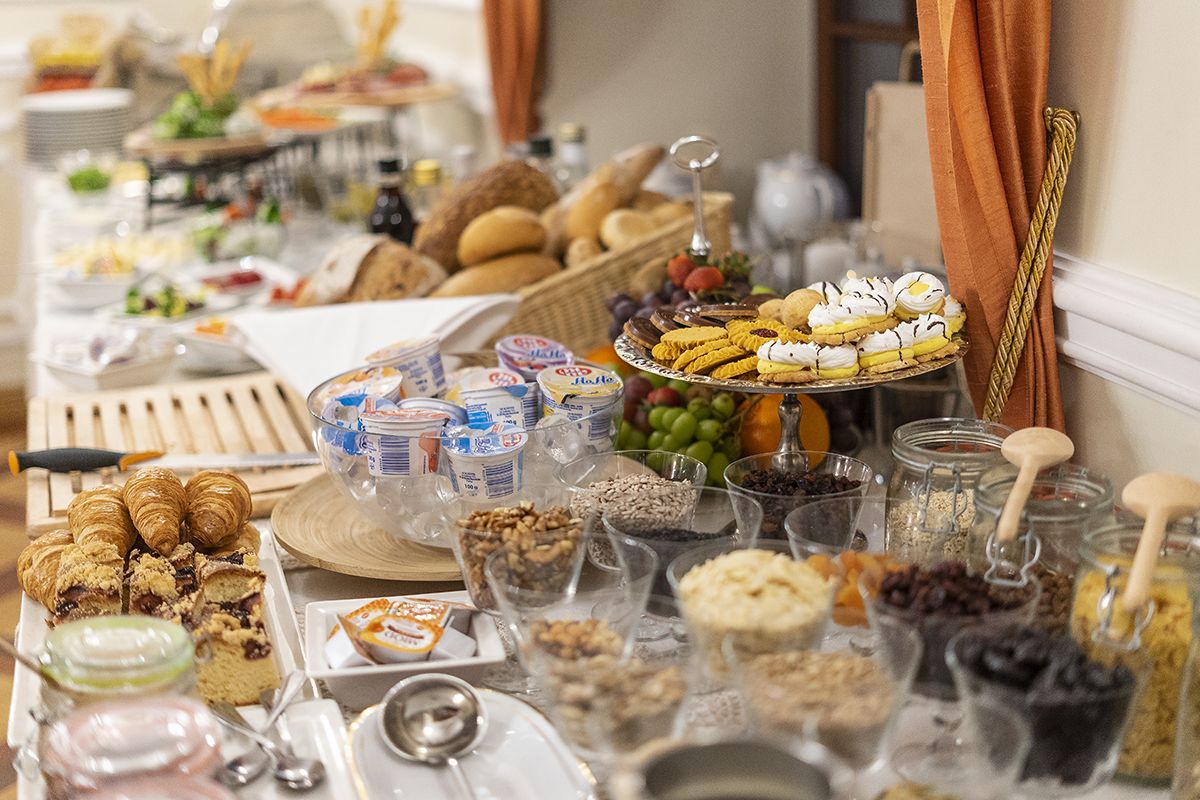 Un tavolo del buffet con diversi cibi, tra cui pasticcini, frutta e salse.