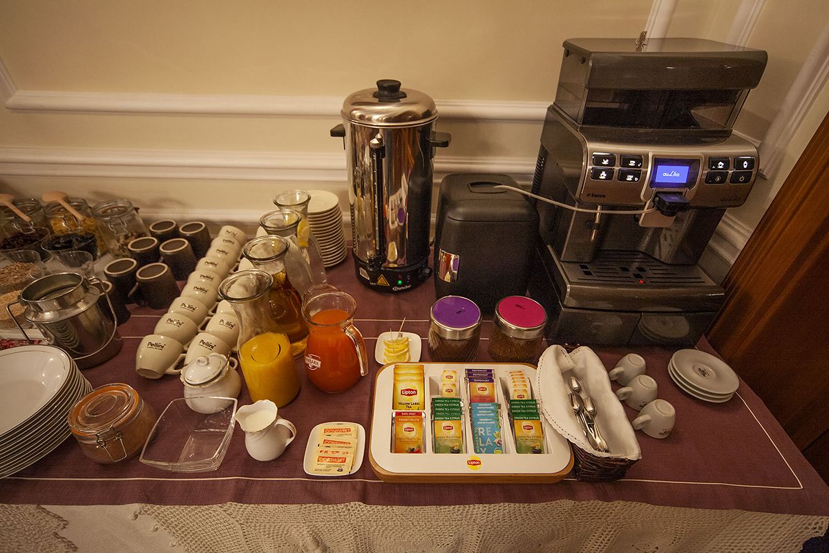 Un buffet de petit-déjeuner comprenant une machine à café, des pots de condiments et une variété d'aliments.