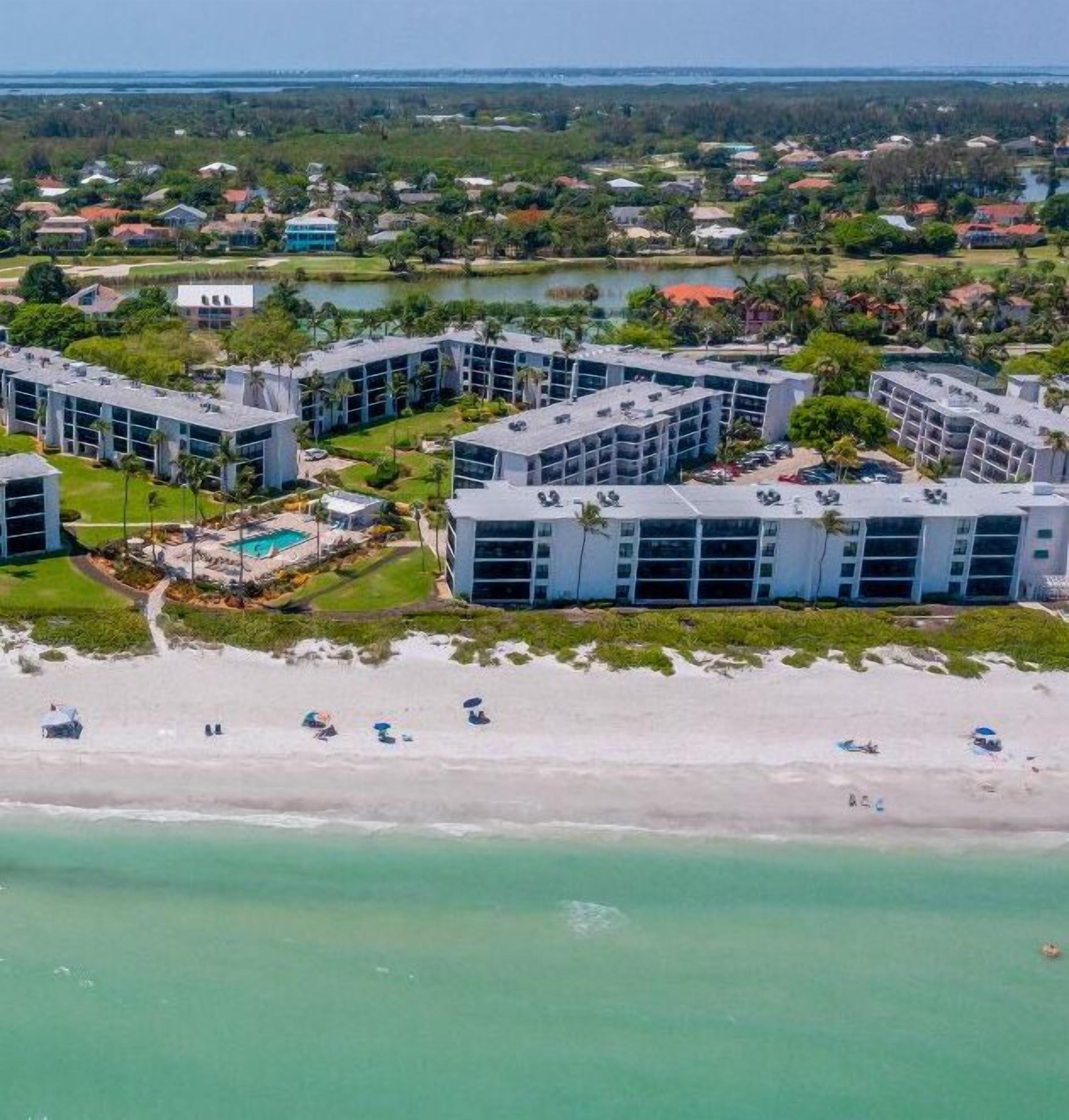 Een kusthotel met meerdere gebouwen, een zwembad en een strandgedeelte.
