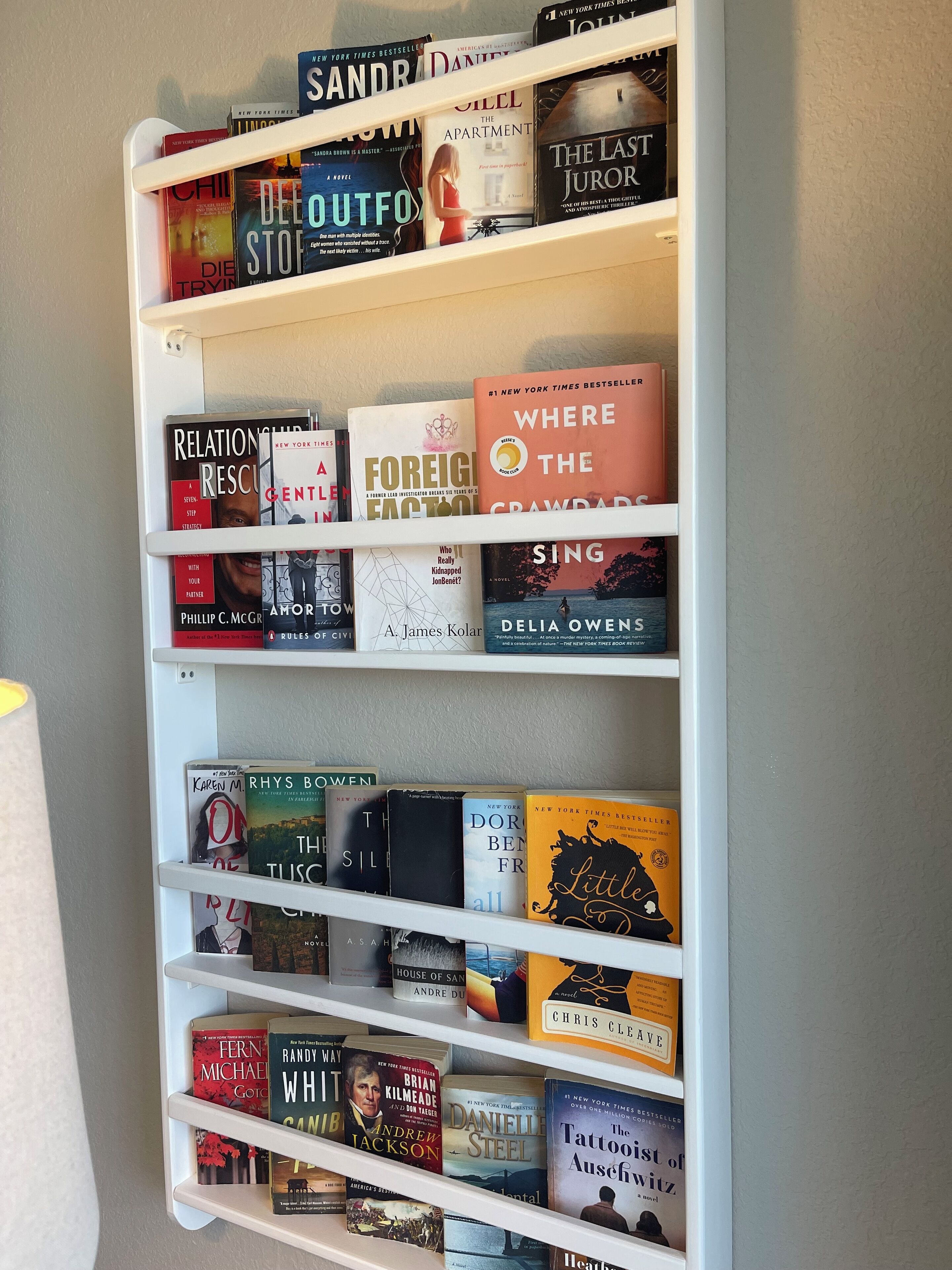 A bookshelf filled with various books, including some New York Times Bestsellers.
