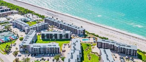 Un hôtel situé sur la côte, composé de plusieurs bâtiments, doté d’une plage et offrant une vue dégagée sur l’océan.