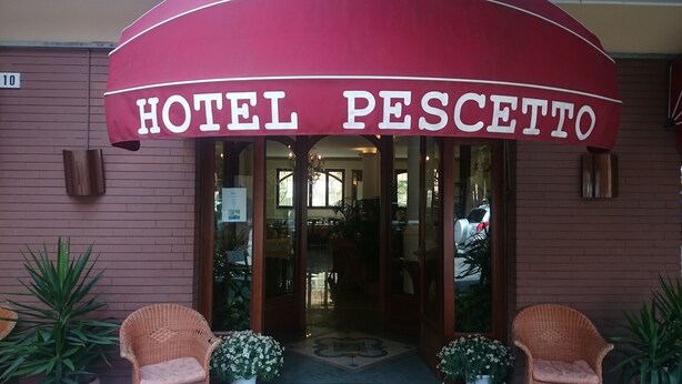A hotel entrance with a red awning labeled "HOTEL PESCETTO." - Hotel Pescetto (Albenga)
