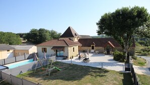 Propiedad residencial con piscina, zona de estar al aire libre y patio cercado.