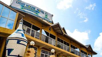 Un hotel con un letrero llamativo que dice "LIGHT HOUSE HOTEL" y "RWANDA-HOUSE".