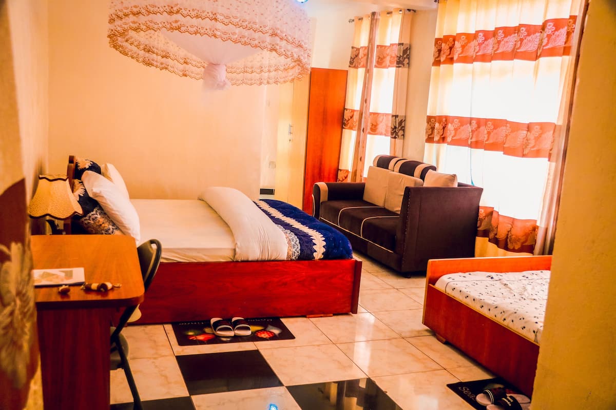 Una habitación de hotel con una cama, un sofá, un escritorio y una silla.