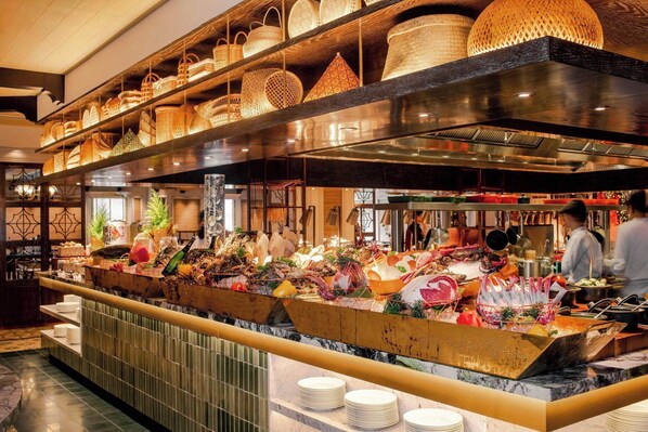 Een visbuffet met diverse gerechten en broden in manden, gepresenteerd op planken.