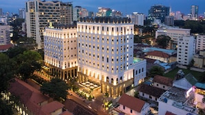 Un hotel de varios pisos con un patio central, rodeado por otros edificios.