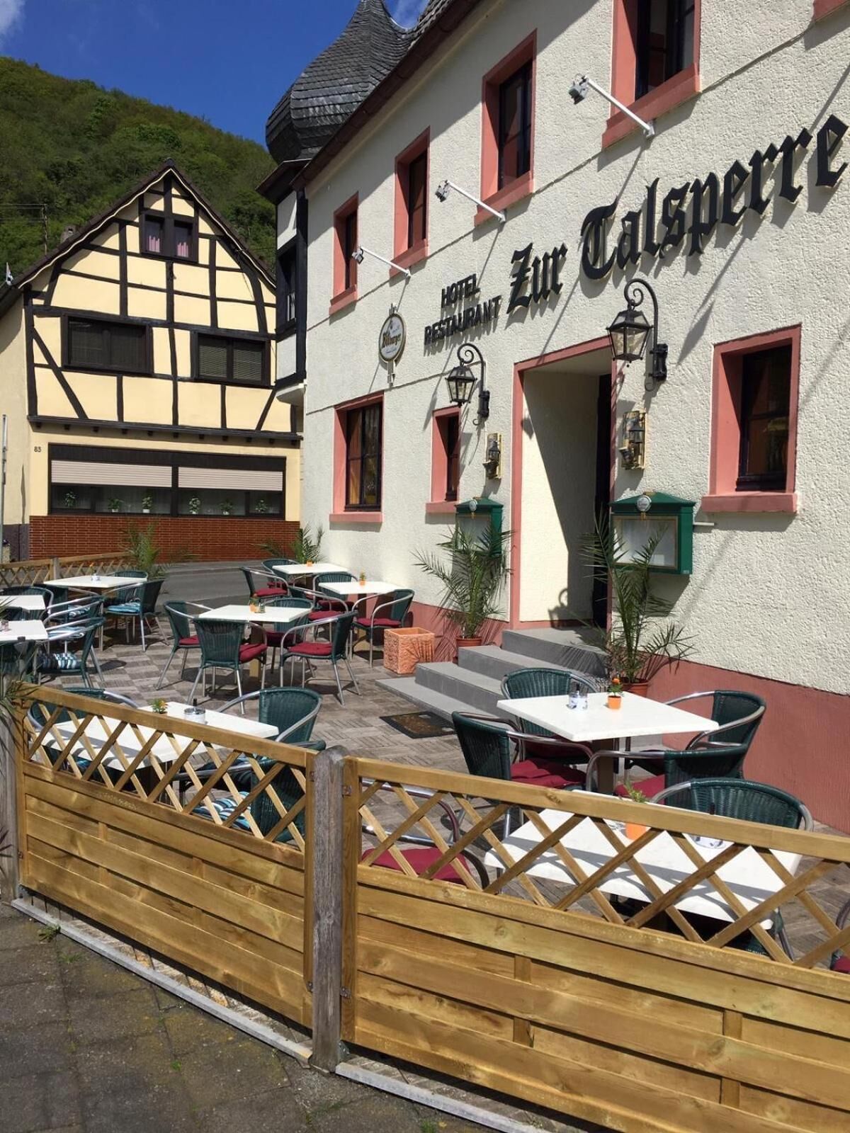 Un hotel tradicional europeo con terraza y un cartel que dice "Hotel Zur Talsperre".