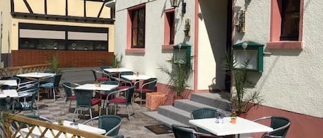 A traditional European hotel with outdoor seating and a sign reading "Hotel Zur Talsperre".