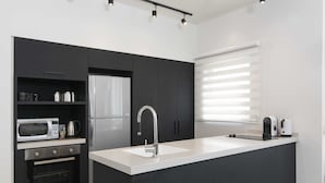 A modern kitchen with a built-in oven, microwave, and refrigerator. - Tlv Center by Tlv2rent (Tel Aviv)