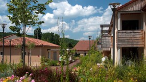 A residential area with houses, a garden with flowers, and a clear sky.