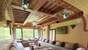 Un interior tradicional con muebles de madera ornamentados, suelo estampado y detalles decorativos en el techo.