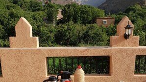 Desayuno preparado en una terraza con vistas a montañas y follaje.