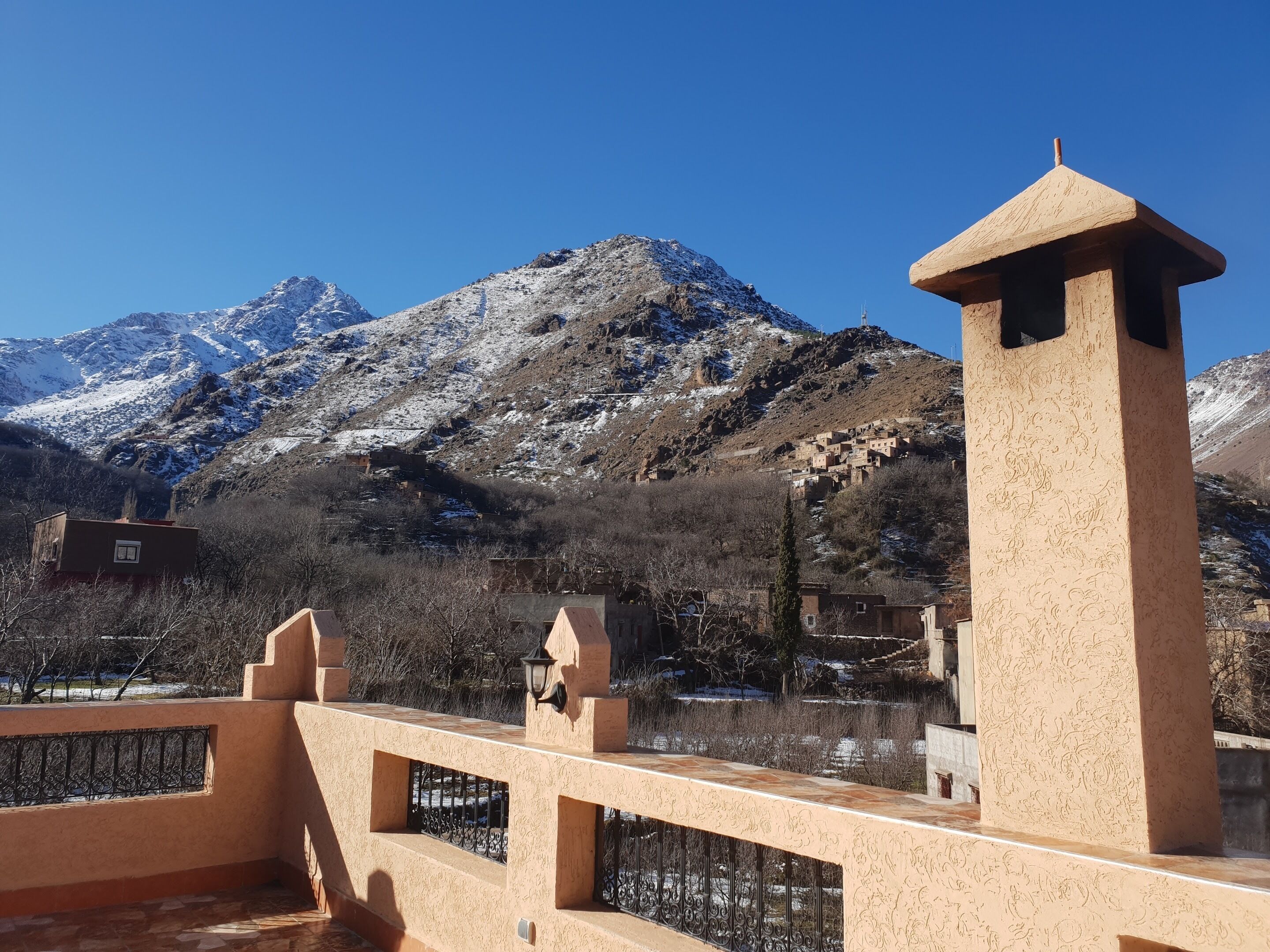 Un paisaje montañoso con picos nevados y un cielo azul despejado.