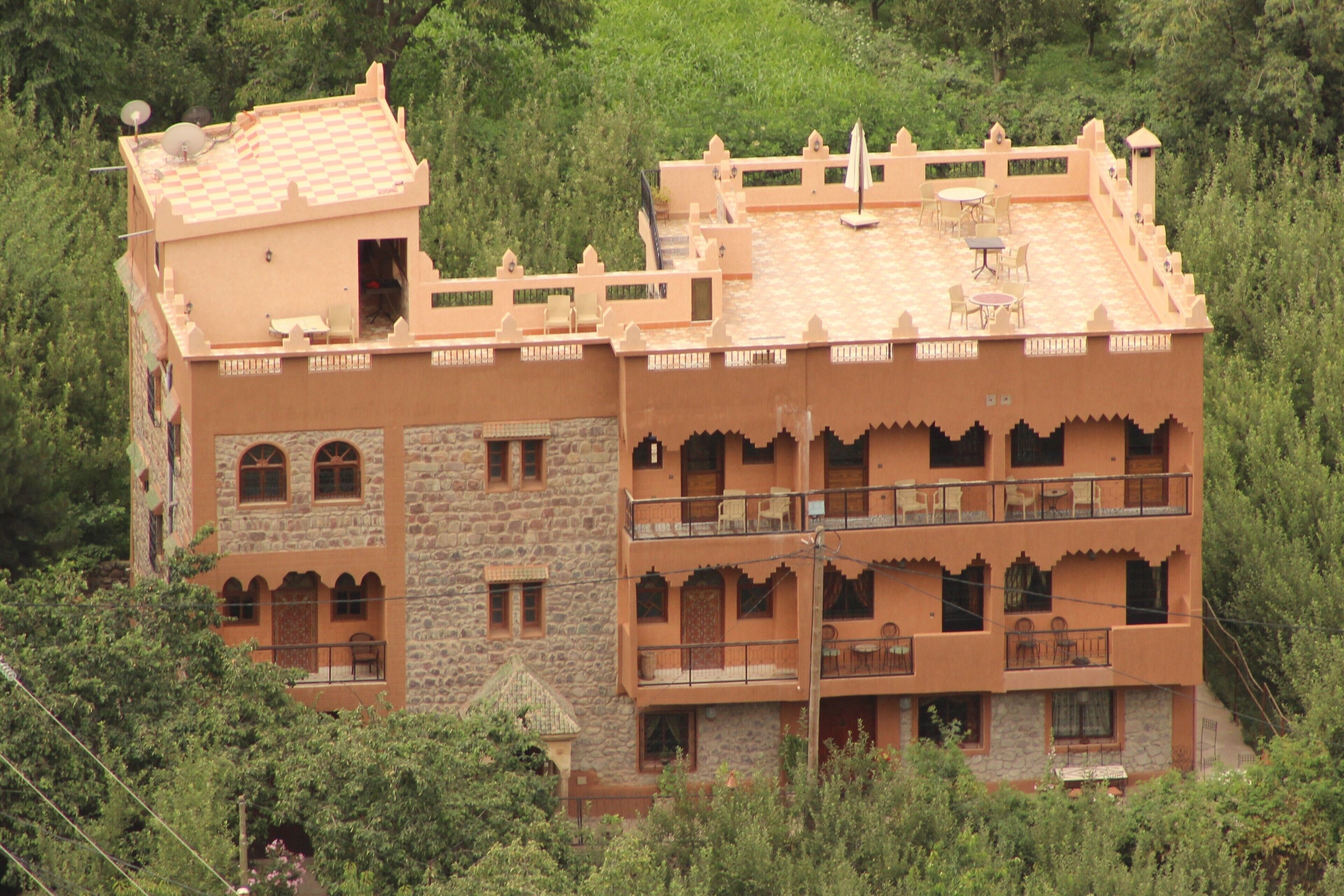 Um edifício com vários andares, varandas, fachada de pedra e telhado plano.