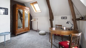 Um quarto com uma mesa de jantar de madeira, cadeiras, um armário e um claraboia.