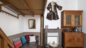 Uma sala de estar aconchegante com um sofá de couro marrom, um armário de madeira e uma lareira.