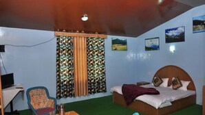 A bedroom with a bed, a desk, a chair, and curtains. - Natures Outpost Camps (Kullu)