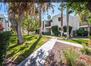 Un edificio residencial con un patio central, rodeado de árboles y arbustos.