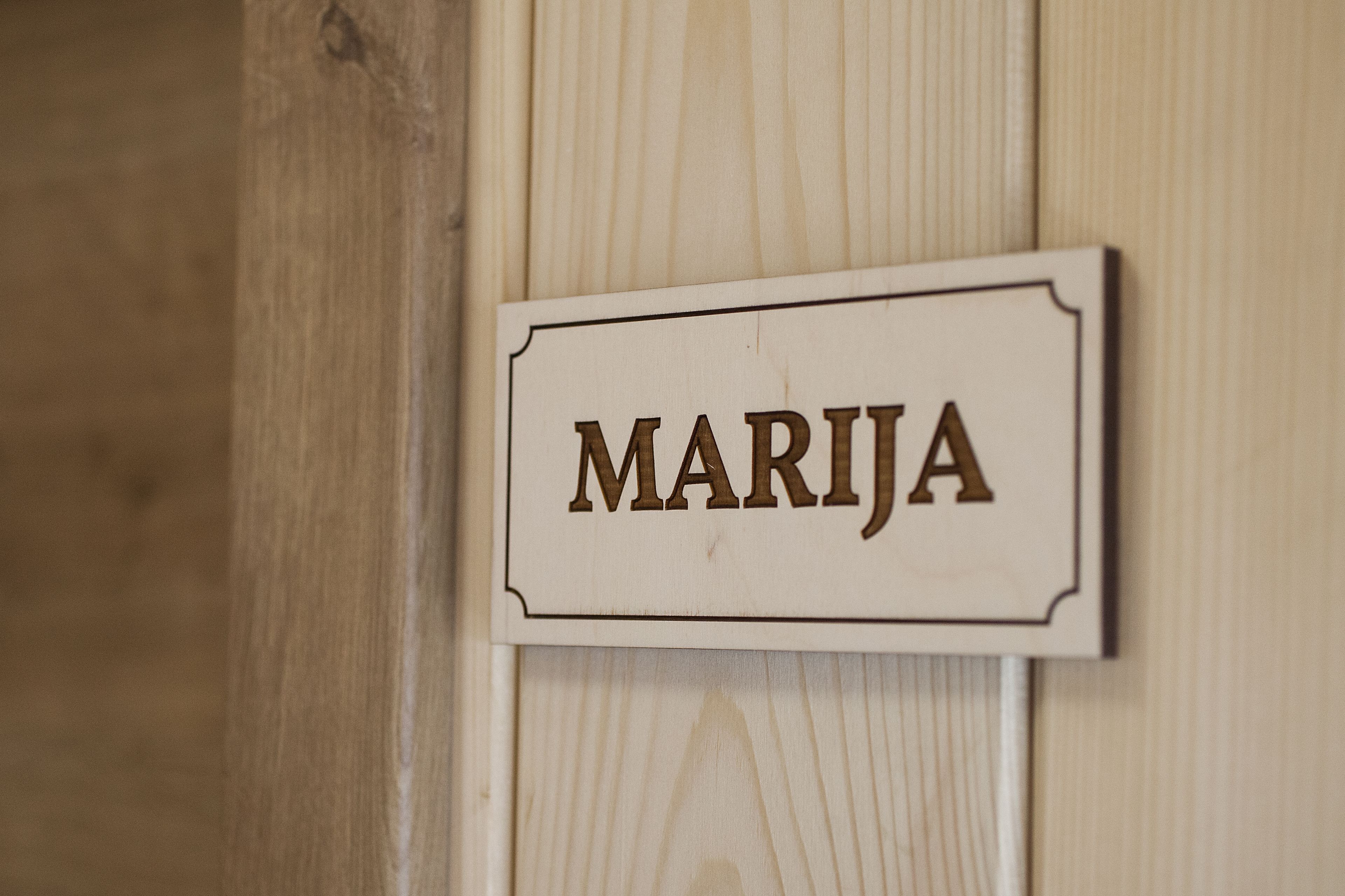 Un letrero de madera con el nombre "MARIJÁ" sujeto a una pared.