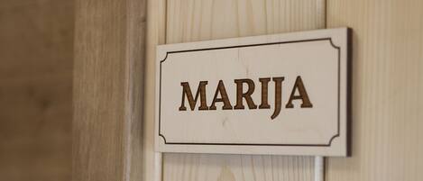 Un letrero de madera con el nombre "MARIJÁ" sujeto a una pared.