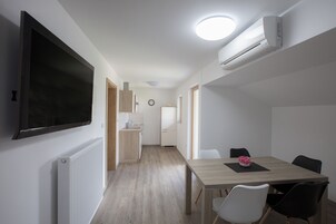 Una cocina moderna con armarios blancos, encimera de madera y horno empotrado.