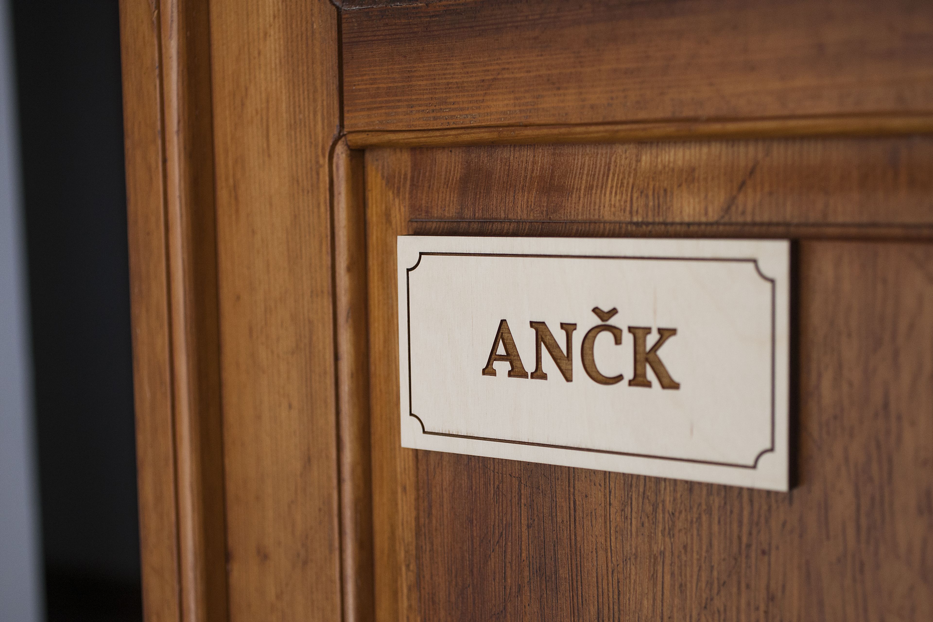 Una puerta de madera con un letrero que dice 'ANČK'.