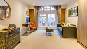 A modern living room with a sofa, a coffee table, a TV, and a fireplace. - Cocoa Suites 5 - sleeps 2 guests  in studio apartment (York)