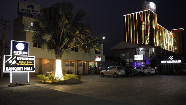 A hotel with a banquet hall, a restaurant, and a parking area at night. - Elite Inn (Bengaluru)
