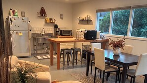 Eine moderne Küche mit Essbereich, inklusive Kühlschrank, Mikrowelle und Spüle.