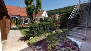 A residential garden with a paved walkway, a metal staircase, and a variety of plants and flowers. - Haus Steinberg (DTV 3 Sterne) - Herbi's holiday apartment - Ground floor   (Burladingen)