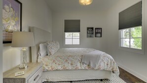 A bedroom with a bed, a nightstand, a lamp, a window with blinds, and a poster on the wall. - The Perfect Hideaway - Plan Your 30 Day Escape (Nashville)