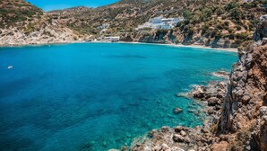 A coastal area with clear turquoise waters, rocky cliffs, and a hillside with buildings. - Beautiful seaview villa with private sea water pool (Agios Nikolaos)