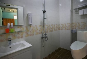 A bathroom with a shower, sink, and toilet.