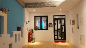Un pasillo con una pared de acento de piedra, una ventana, una puerta y una bomba de gas roja.