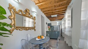 Un coin repas avec une table ronde, des chaises transparentes et un miroir décoratif.