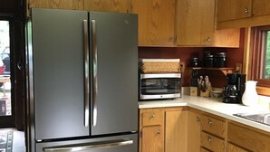 A modern kitchen with wooden cabinets, stainless steel appliances, and a built-in oven.