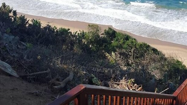 A wooden deck leading to a beach with ocean views. - Alfies House (Ponta d'Ouro)