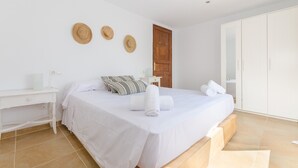 A bedroom with a bed, a nightstand, a wardrobe, and a door.