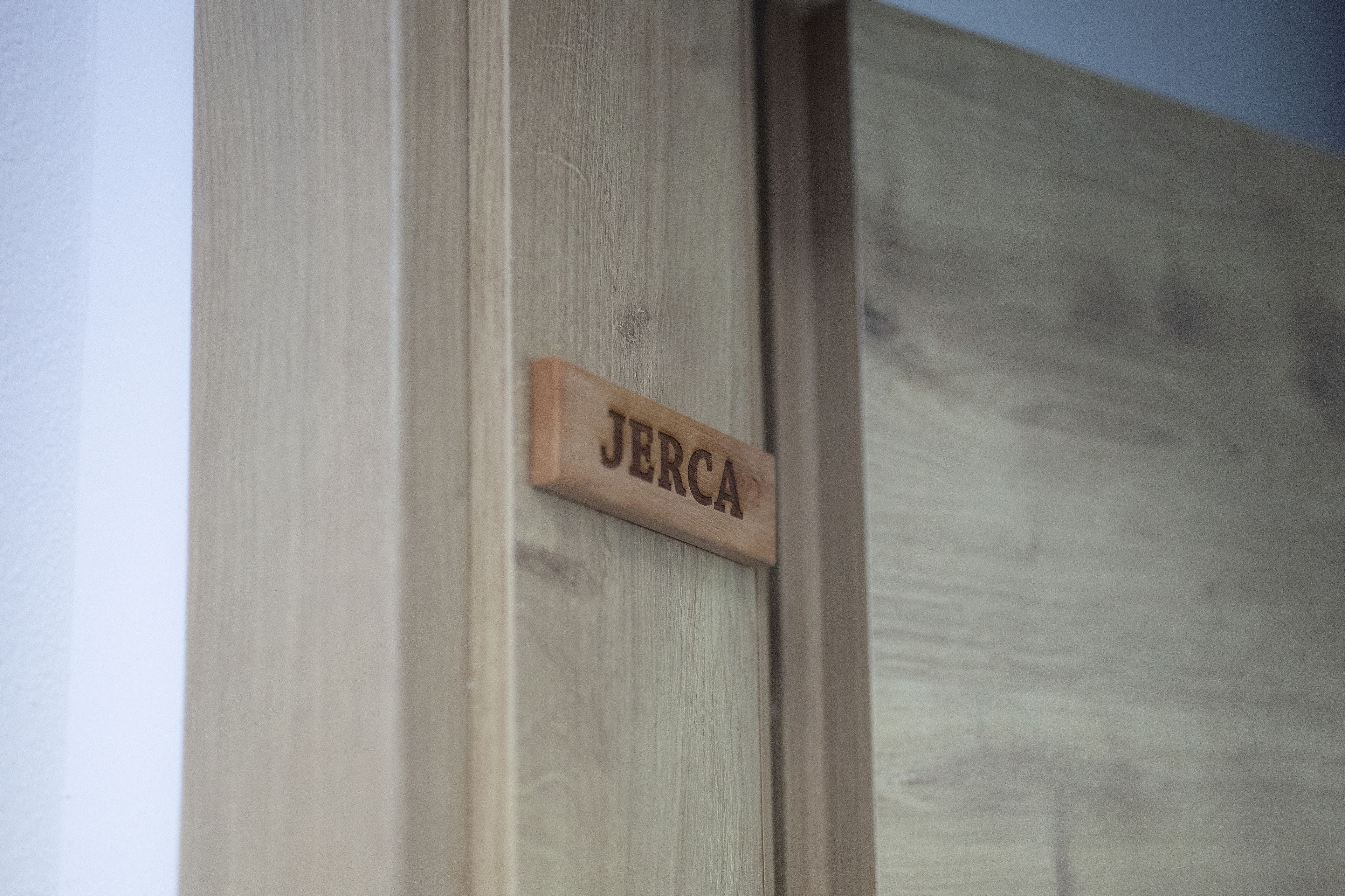 A wooden nameplate with the name "JERCA" on a door.