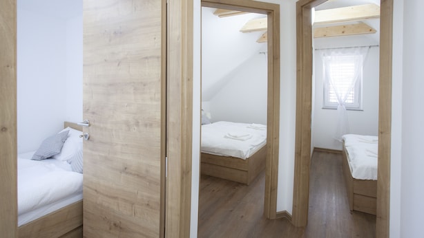 Une chambre avec un lit en bois, une armoire en bois et une fenêtre avec un rideau.